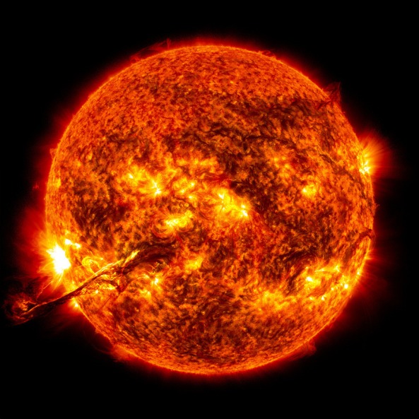 A solar flare erupts from the surface of the sun.